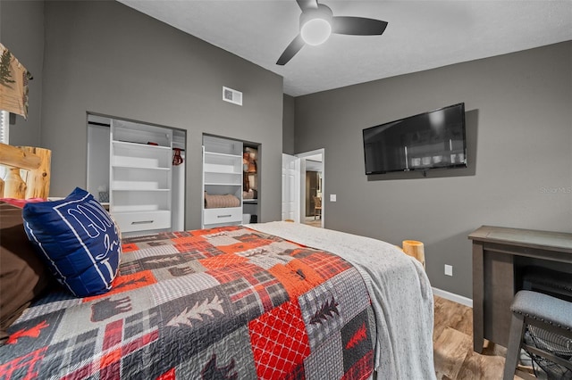 bedroom with visible vents, ceiling fan, wood finished floors, and baseboards