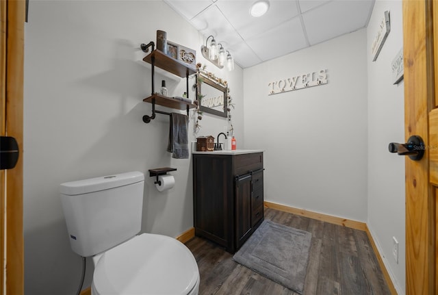 bathroom featuring toilet, wood finished floors, vanity, and baseboards