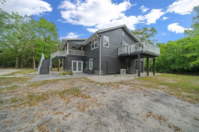 back of house featuring central air condition unit, stairway, french doors, a ceiling fan, and a deck