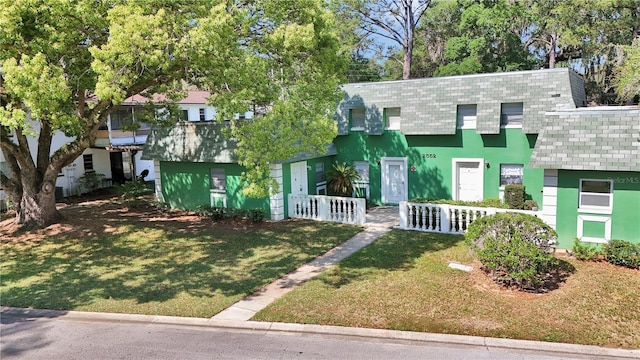 view of front facade featuring a front yard, stucco siding, and a fenced front yard