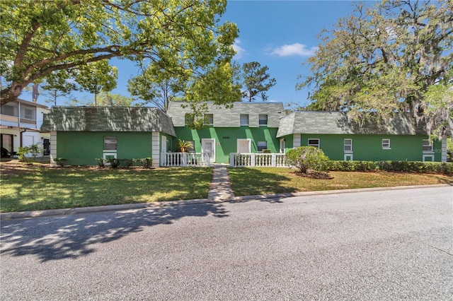 view of front of home featuring a front lawn, fence, and a shingled roof