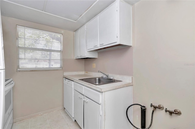 kitchen featuring light tile patterned floors, a sink, light countertops, white appliances, and white cabinetry