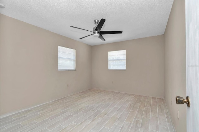 empty room featuring a textured ceiling, a ceiling fan, and light wood finished floors