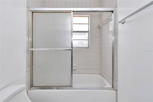 full bathroom with toilet and bath / shower combo with glass door
