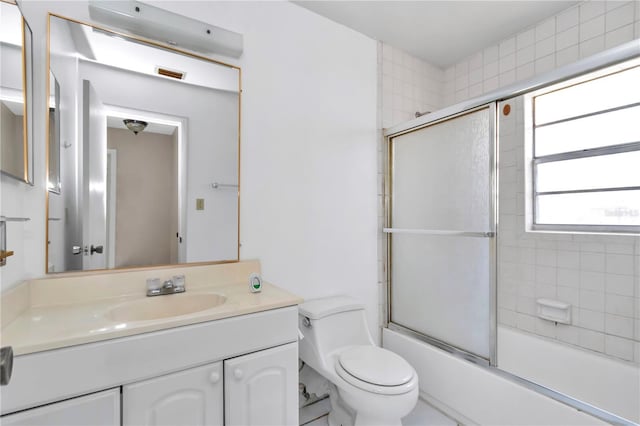 full bathroom with toilet, vanity, and enclosed tub / shower combo