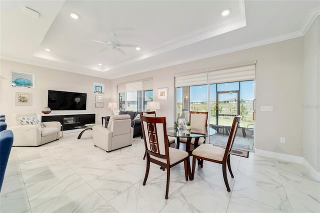 dining area with a raised ceiling, baseboards, a ceiling fan, marble finish floor, and ornamental molding