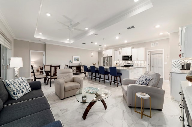living room featuring ceiling fan, recessed lighting, visible vents, and a raised ceiling