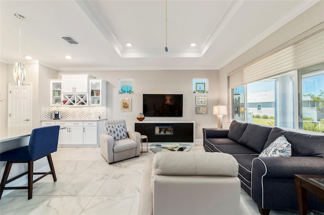 living area with recessed lighting, marble finish floor, a raised ceiling, visible vents, and ornamental molding