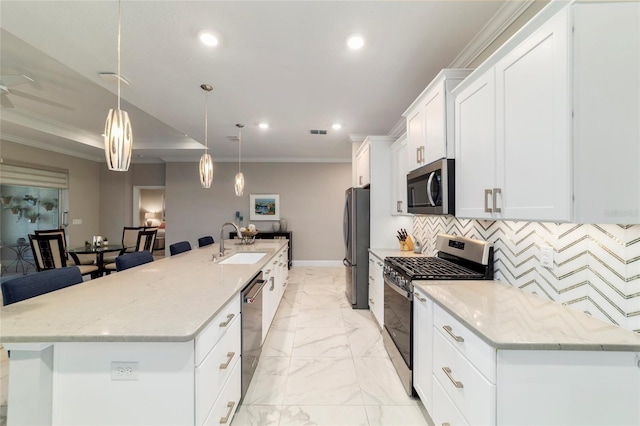 kitchen featuring recessed lighting, ornamental molding, a sink, a spacious island, and appliances with stainless steel finishes