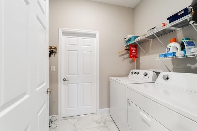 laundry area featuring washing machine and dryer, baseboards, marble finish floor, and laundry area