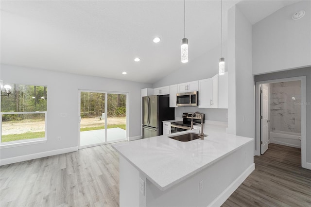 15840 SW 38th Pl, Ocala, FL 34481 - kitchen featuring white cabinets, light countertops, light wood-style floors, stainless steel appliances, and lofted ceiling