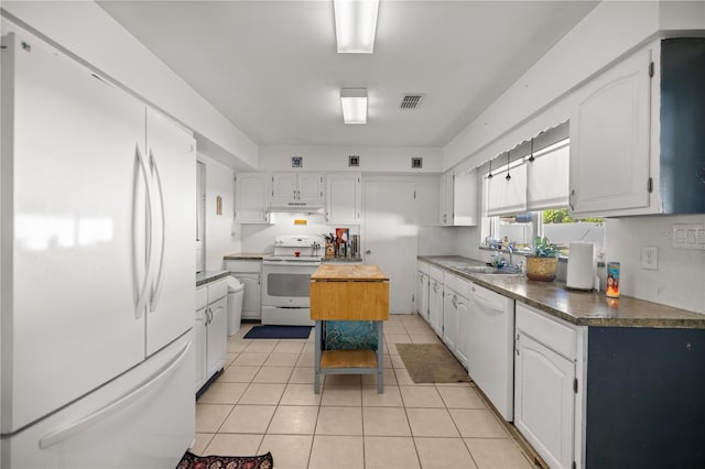 kitchen with white appliances, light tile patterned floors, under cabinet range hood, visible vents, and a sink