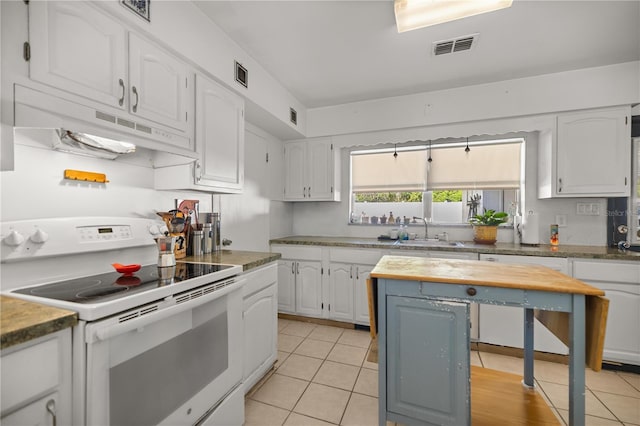 kitchen with white appliances, visible vents, white cabinets, under cabinet range hood, and a sink
