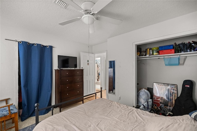bedroom with visible vents, a ceiling fan, a closet, and a textured ceiling
