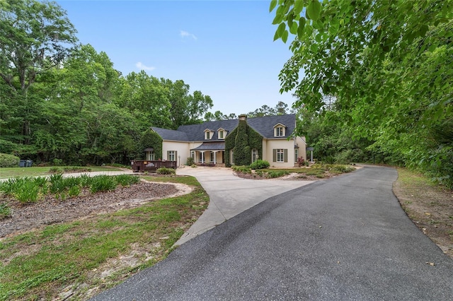 1251 SW 43rd Pl, Ocala, FL 34471 - french provincial home with stucco siding, a chimney, driveway, and a wooden deck