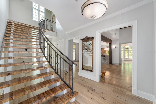 1251 SW 43rd Pl, Ocala, FL 34471 - staircase with crown molding, baseboards, wood finished floors, and high vaulted ceiling