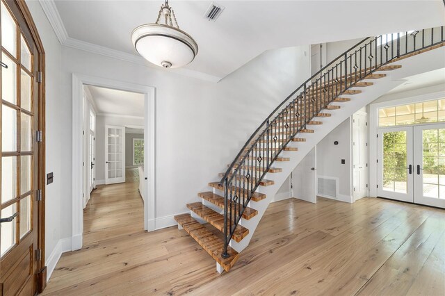 1251 SW 43rd Pl, Ocala, FL 34471 - stairs featuring french doors, crown molding, wood-type flooring, and plenty of natural light