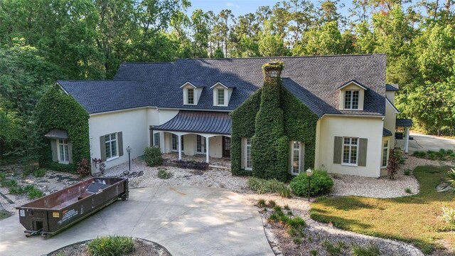 1251 SW 43rd Pl, Ocala, FL 34471 - view of front facade featuring covered porch, stucco siding, a chimney, and a shingled roof