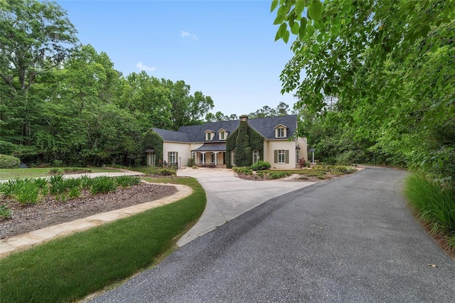 1251 SW 43rd Pl, Ocala, FL 34471 - french country home featuring a chimney, stucco siding, and driveway
