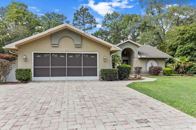 single story home featuring stucco siding, decorative driveway, and an attached garage