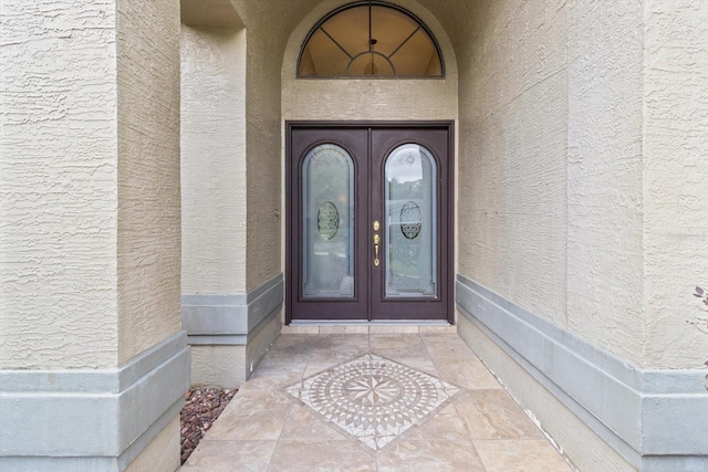 entrance to property featuring stucco siding