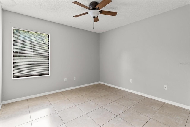 unfurnished room with ceiling fan, baseboards, and a textured ceiling