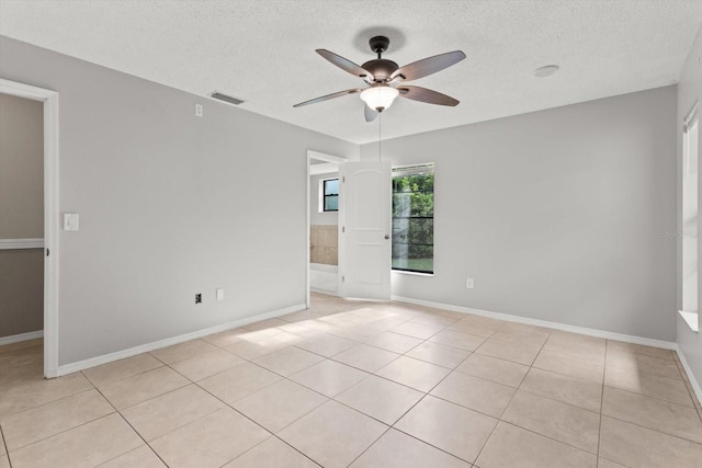 unfurnished room with visible vents, baseboards, ceiling fan, a textured ceiling, and light tile patterned flooring