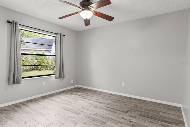 unfurnished room featuring a textured ceiling, baseboards, and wood finished floors