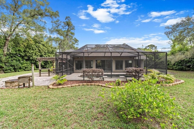back of house featuring a patio area, a yard, a lanai, and an outdoor fire pit