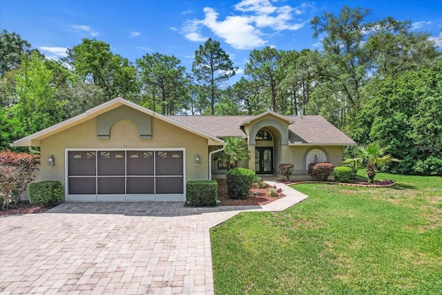 view of front of home featuring roof with shingles, stucco siding, decorative driveway, a front lawn, and a garage