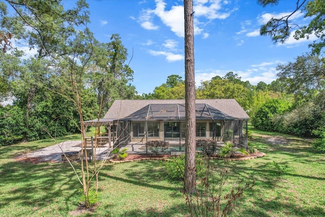 rear view of house with a patio, a yard, and a lanai