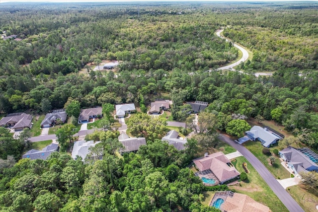 drone / aerial view featuring a forest view and a residential view