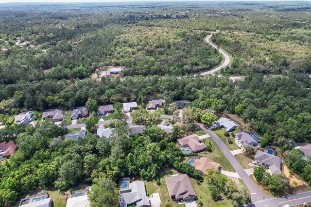 drone / aerial view featuring a wooded view and a residential view