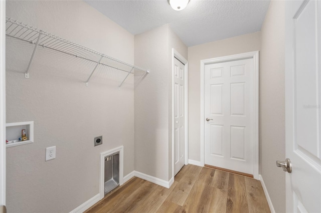 laundry area featuring laundry area, washer hookup, light wood finished floors, baseboards, and electric dryer hookup