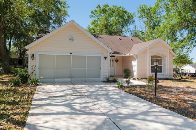 ranch-style house with roof with shingles, concrete driveway, and a garage