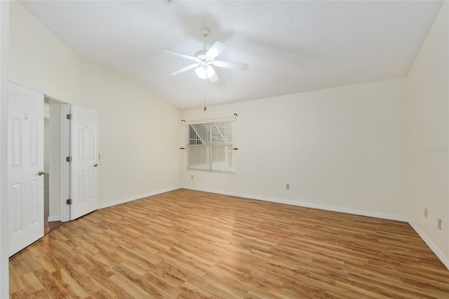spare room featuring baseboards, light wood-type flooring, and a ceiling fan
