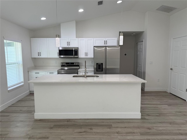 kitchen with white cabinetry, visible vents, a sink, lofted ceiling, and stainless steel appliances