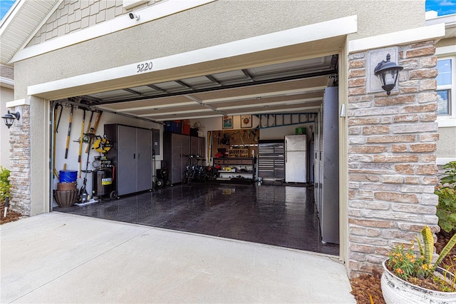5220 Sunshine Dr, Wildwood, FL 34785 - garage featuring freestanding refrigerator and concrete driveway