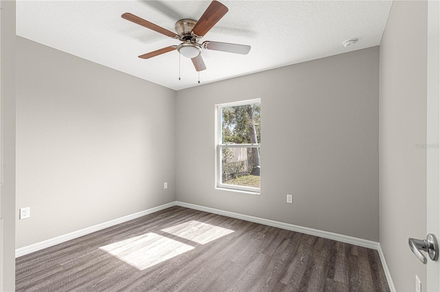 unfurnished room featuring wood finished floors, baseboards, and a ceiling fan