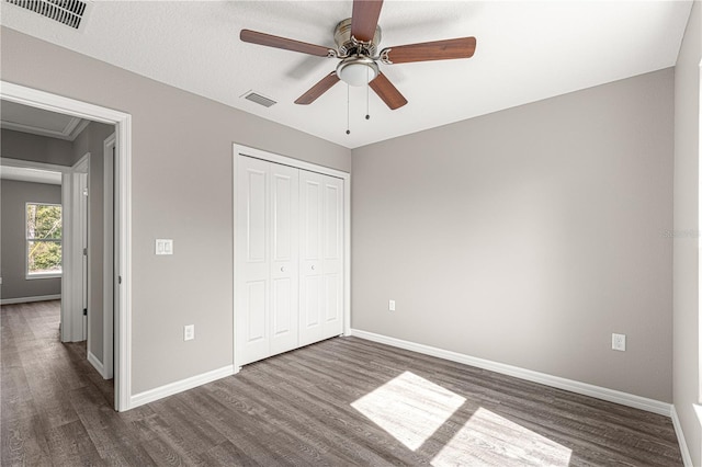 unfurnished bedroom with dark wood-type flooring, baseboards, and visible vents