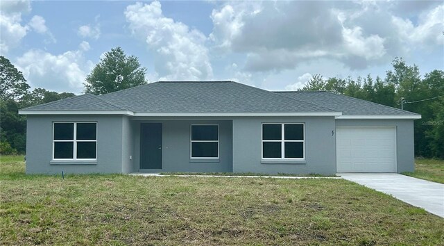 87 Guava Pass Dr, Ocklawaha, FL 32179 - view of front facade with an attached garage, driveway, stucco siding, and a front lawn