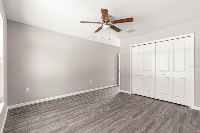 87 Guava Pass Dr, Ocklawaha, FL 32179 - unfurnished bedroom featuring wood finished floors, a closet, a ceiling fan, and a textured ceiling