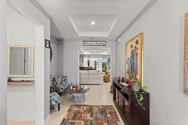 corridor featuring a raised ceiling