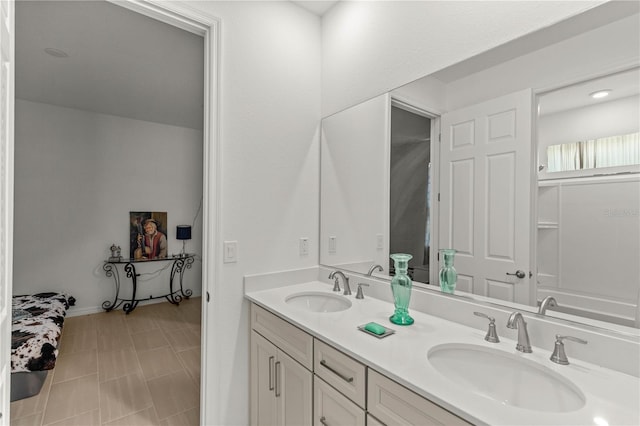 full bathroom with a sink, baseboards, and double vanity