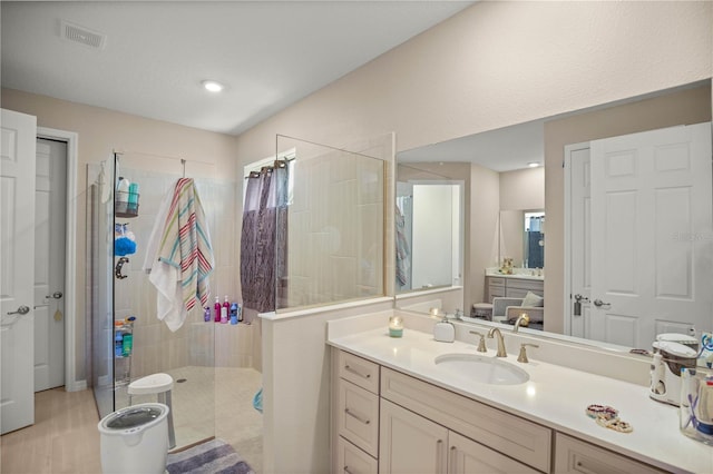 bathroom with vanity, visible vents, and a tile shower