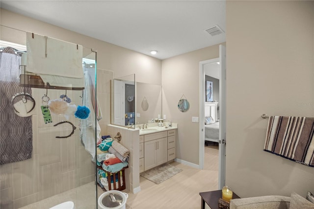 bathroom featuring visible vents, ensuite bathroom, a walk in shower, vanity, and wood finished floors