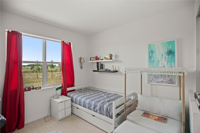bedroom featuring baseboards and multiple windows