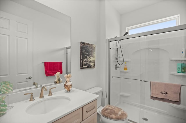 full bath with a shower stall, vanity, and toilet