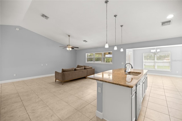 kitchen with light tile patterned floors, a sink, vaulted ceiling, and visible vents
