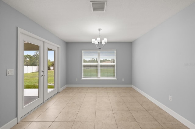 unfurnished dining area featuring baseboards, light tile patterned floors, a notable chandelier, and visible vents
